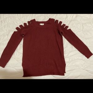 Dark burgundy sweater with shoulder cut sleeves and side slits.